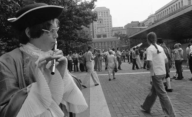 FILE - A young flute player in colonial costume plays "Yankee Doodle" for crowds gathering to visit the Liberty Bell in Philadelphia, July 3, 1976. (AP Photo/Bill Ingraham, File)