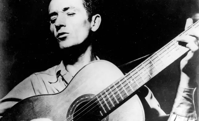 FILE - In this undated photo Oklahoma folk singer Woody Guthrie plays his guitar. (AP Photo, File)