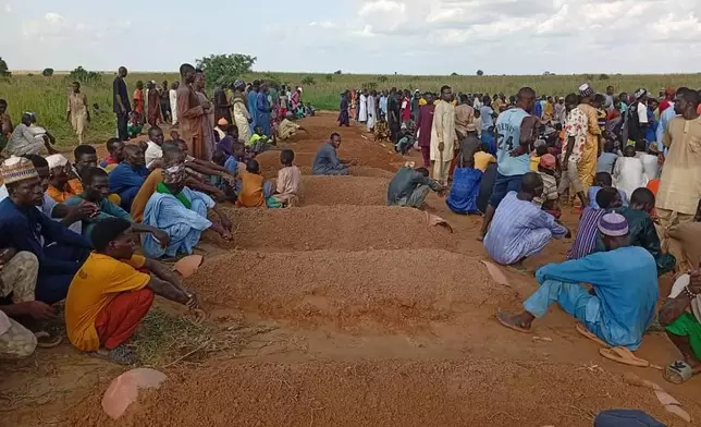 People attend a funeral for those who died after a boat capsized in Sokoto, northwestern Nigeria, Thursday, Aug. 20, 2026. (AP Photo/Usman Yusuf)