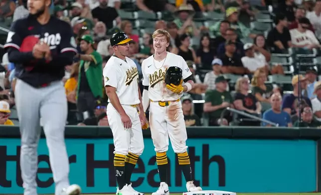 Athletics Henry Bolte, center, talks with Athletics third base coach Bobby Crosby (8) after hitting a triple during the seventh inning of a baseball game against the Minnesota Twins Tuesday, Aug. 25, 2026, in West Sacramento, Calif. (AP Photo/Alan Greth)
