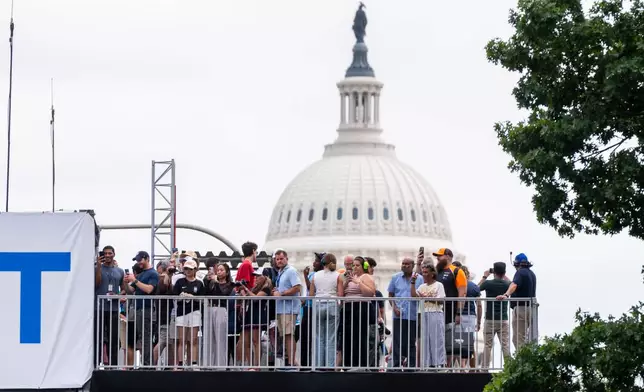 Spectators watch from an overpass near the U.S. Capitol as race car drivers take practice runs along Pennsylvania Avenue prior to Sunday's Freedom 250 Grand Prix auto race in Washington, Saturday, Aug. 22, 2026. (AP Photo/Manuel Balce Ceneta)