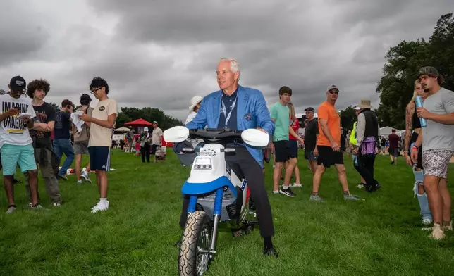 Penske Automotive Group President Bud Denker shows off a Freedom 250 bike in the fan zone ahead of the Freedom 250 Grand Prix auto race, Saturday, Aug. 22, 2026, in Washington. (AP Photo/Allison Robbert)