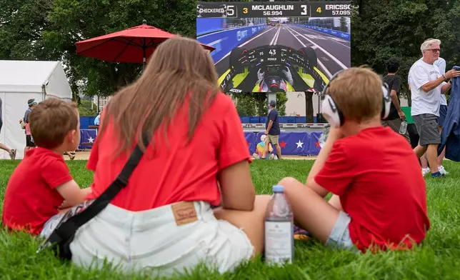 Fans watch racing on a screen in the fan zone during a practice run prior to Sunday's Freedom 250 Grand Prix auto race in Washington, Saturday, Aug. 22, 2026. (AP Photo/Jacquelyn Martin)
