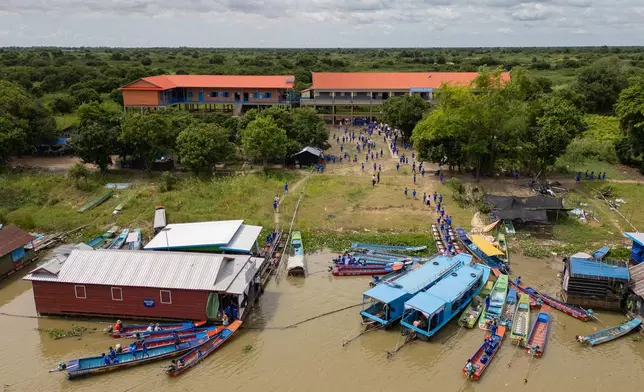 Students arrive at a school in a floating village on the Tonle Sap Lake, Cambodia, Tuesday, June 30, 2026. (AP Photo/Anton L. Delgado)