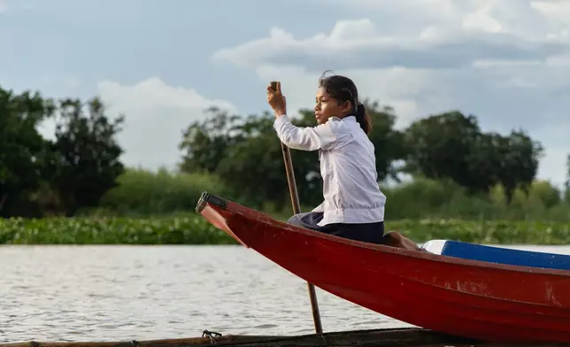 A student from a floating village steers a school boat on Tonle Sap Lake, Cambodia, Monday, June 29, 2026. (AP Photo/Anton L. Delgado)