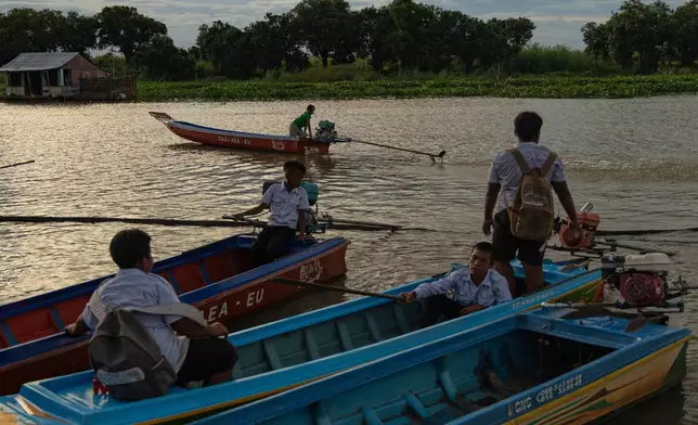 Students board school boats to return to their homes in a floating village on Cambodia's Tonle Sap Lake on Monday, June 29, 2026. (AP Photo/Anton L. Delgado)