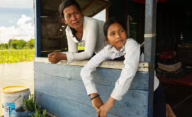 Nhim San, left, and her daughter, Sou Sreynich, at their home in a floating village on Cambodia's Tonle Sap Lake on Monday, June 29, 2026. (AP Photo/Anton L. Delgado)
