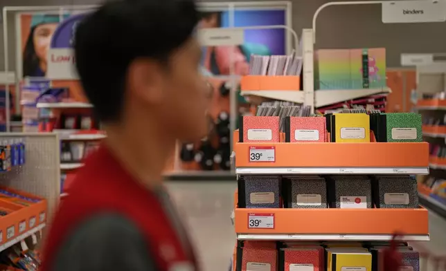 An employee passes the back-to-school section at a Target store, Thursday, Aug. 13, 2026, in Woodbury, Minn. (AP Photo/Ellen Schmidt)