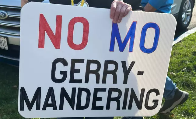 FILE - A person holds a sign opposing the new U.S. House districts passed by the Missouri General Assembly during a protest outside the state Capitol, in Jefferson City, Mo., March 10, 2026. (AP Photo/David A. Lieb, File)