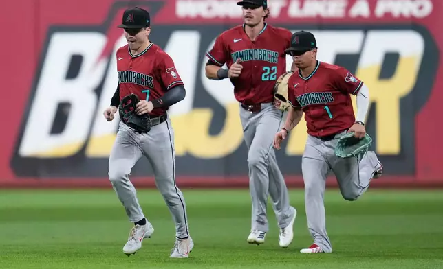 Arizona Diamondbacks outfielders Corbin Carroll (7), Max Kepler (22) and Jorge Barrosa (1) run in from the outfield after the Diamondbacks defeated the Guardians in a baseball game in Cleveland, Friday, July 31, 2026. (AP Photo/Sue Ogrocki)