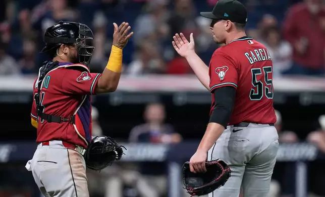 Arizona Diamondbacks catcher Gabriel Moreno, left, and pitcher Brandyn Garcia (55) celebrate after the Diamondbacks defeated the Guardians in a baseball game in Cleveland, Friday, July 31, 2026. (AP Photo/Sue Ogrocki)