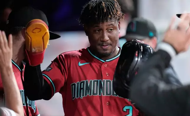 Arizona Diamondbacks' Geraldo Perdomo (2) is congratulated in the dugout after scoring in the eighth inning of a baseball game against the Cleveland Guardians in Cleveland, Friday, July 31, 2026. (AP Photo/Sue Ogrocki)