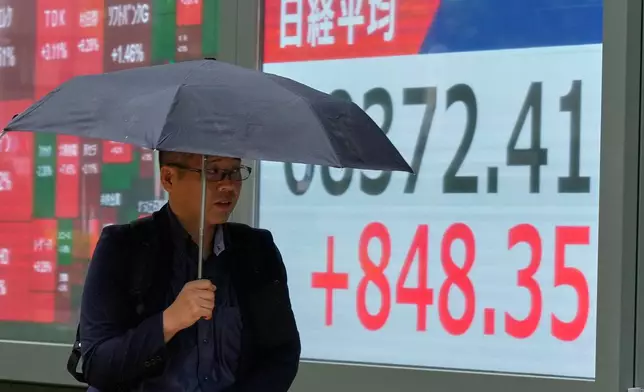 A person walks in front of an electronic stock chart board showing Japan's Nikkei index at a securities firm Thursday, Aug. 13, 2026, in Tokyo. (AP Photo/Eugene Hoshiko)