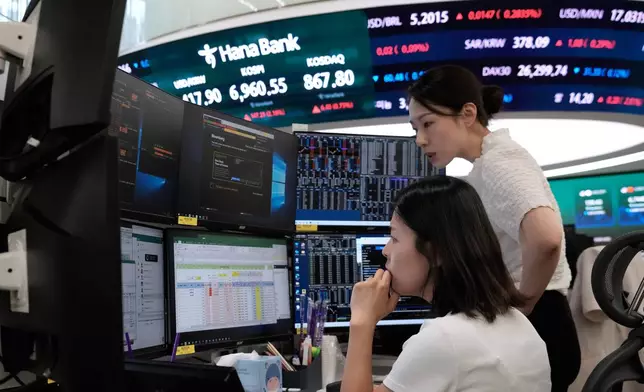 Currency traders work at the foreign exchange dealing room of the Hana Bank headquarters in Seoul, South Korea, Friday, Aug. 14, 2026. (AP Photo/Ahn Young-joon)