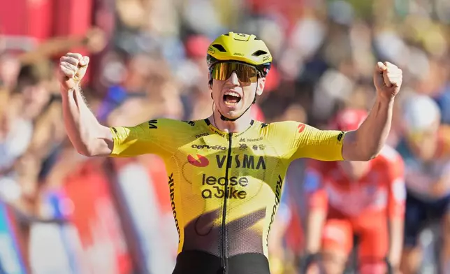Britain's Matthew Brennan celebrates as he crosses the finish line to win the second stage of the La Vuelta cycling race, with start in Monaco and finish in Manosque, France, Sunday, Aug. 23, 2026. (AP Photo/Philippe Magoni)