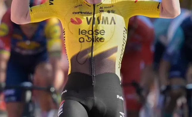 Britain's Matthew Brennan celebrates as he crosses the finish line to win the second stage of the La Vuelta cycling race, with start in Monaco and finish in Manosque, France, Sunday, Aug. 23, 2026. (AP Photo/Philippe Magoni)