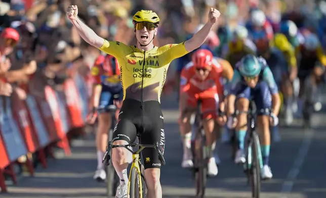 Britain's Matthew Brennan celebrates as he crosses the finish line to win the second stage of the La Vuelta cycling race, with start in Monaco and finish in Manosque, France, Sunday, Aug. 23, 2026. (AP Photo/Philippe Magoni)