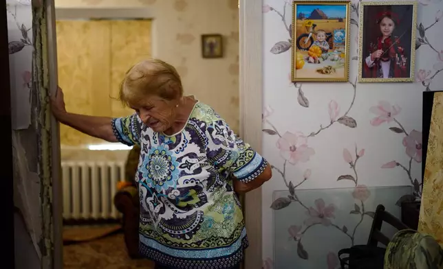 Valentyna Svertoka, 86, leans against a doorframe as she cleans her apartment in a partially damaged residential building the day after a Russian missile and drone attack in Kyiv, Friday, Aug. 21, 2026. (AP Photo/Francisco Seco)