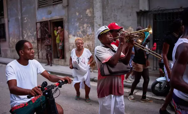 A woman dances as conga musicians play in the streets of Old Havana, Cuba, Wednesday, Aug. 26, 2026. (AP Photo/Ramon Espinosa)