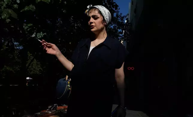 A woman walks on a sidewalk at Islamic Revolution street in downtown Tehran, Iran, Saturday, Aug. 29, 2026. (AP Photo/Vahid Salemi)