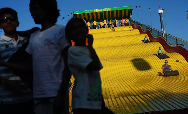 Fairgoers ride the giant slide, Thursday, Aug. 27, 2026, at the Minnesota State Fair in Falcon Heights, Minn. (AP Photo/Ellen Schmidt)