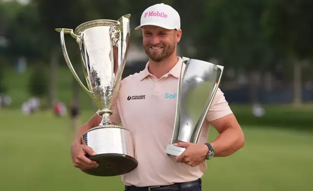 Wyndham Clark holds the Wanamaker Trophy and the BMW trohy after winning the BMW Championship golf tournament, Sunday, Aug. 23, 2026, in St. Louis. (AP Photo/Jeff Roberson)