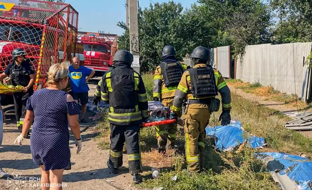 EDS NOTE: GRAPHIC CONTENT - In this photo, provided by the Ukrainian Emergency Service, rescuers carry a body that they removed from under the rubble of a private house following a Russian air attack in Pechenihy, Kharkiv region, Ukraine, Tuesday, Aug. 18, 2026. (Ukrainian Emergency Service via AP)