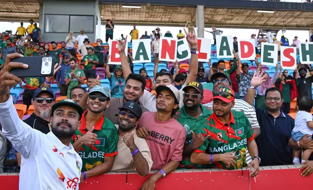 Mehidy Hasan Miraz of Bangladesh takes a selfie with fans after defeating Australia on day four of the first cricket test in Darwin, Australia, Sunday, Aug. 16, 2026. (James Ross/AAP Image via AP)