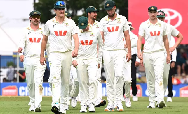 Australian captain Pat Cummins, second left, leads his players from the field following their nine wicket loss to Bangladesh on day four of the first cricket test in Darwin, Australia, Sunday, Aug. 16, 2026. (James Ross/AAP Image via AP)