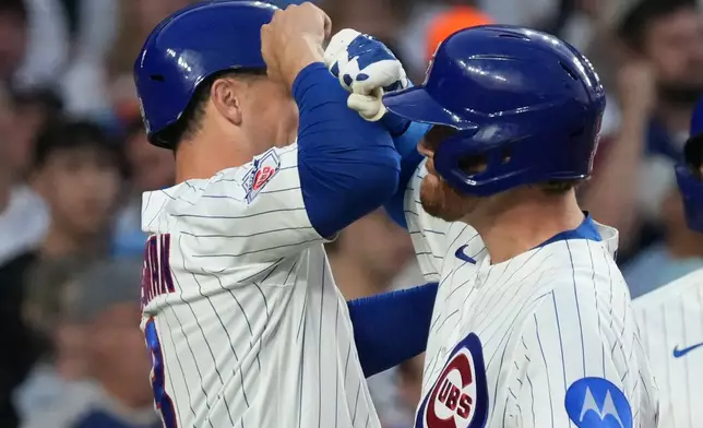 Chicago Cubs' Carson Kelly, right, is greeted by Alex Bregman, left, after hitting a two-run home run against the Los Angeles Dodgers during the third inning of a baseball game Monday, Aug. 3, 2026, in Chicago. (AP Photo/David Banks)
