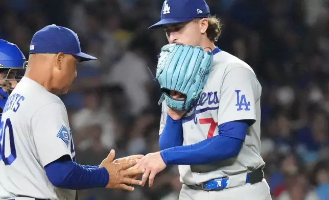 Los Angeles Dodgers pitcher Justin Wrobleski, right, gives the ball to manager Dave Roberts, front left, as he is taken out during the fifth inning of a baseball game against the Chicago Cubs, Monday, Aug. 3, 2026, in Chicago. (AP Photo/David Banks)
