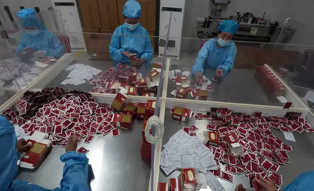 Workers pack traditional Tibetan medicine produced by the Xizang Gansu Tibetan Medicine Co. Ltd in Lhasa, in western China's Tibet Autonomous Region on Wednesday, July 22, 2026 as seen during a government organized visit for foreign journalists. (AP Photo/Ng Han Guan)