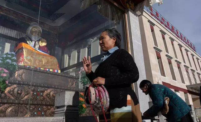Women perform circumambulations around a statue of Tibetan medical master Yutok Nyingma Yonten Gonpo outside the Xizang Autonomous Region Hospital of Tibetan Medicine in Lhasa, in western China's Tibet Autonomous Region on Wednesday, July 22, 2026 as seen during a government organized visit for foreign journalists. (AP Photo/Ng Han Guan)