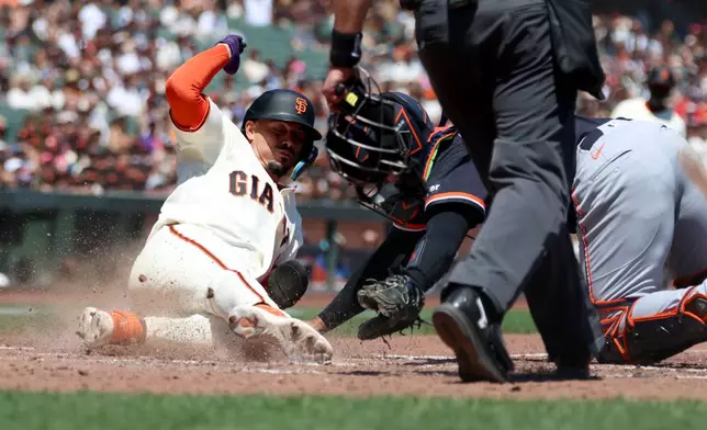 San Francisco Giants' Willy Adames, left, is tagged out by Detroit Tigers catcher Eduardo Valencia, back right, on a ball hit by Drew Gilbert during the fourth inning of a baseball game in San Francisco, Sunday, Aug. 9, 2026. (AP Photo/Jed Jacobsohn)