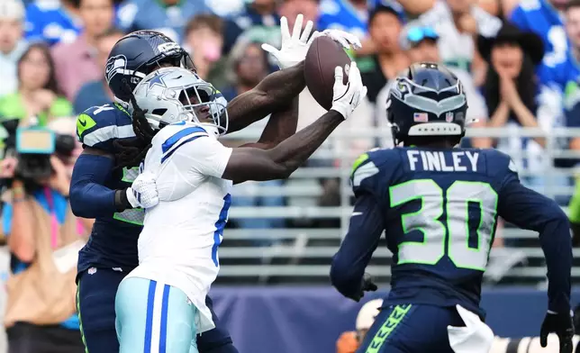 Dallas Cowboys wide receiver Camden Brown, center, catches a touchdown pass as Seattle Seahawks' Shemar Jean-Charles, left, and AJ Finley (30) defend in the first half of an NFL preseason football game, Saturday, Aug. 15, 2026, in Seattle. (AP Photo/Lindsey Wasson)