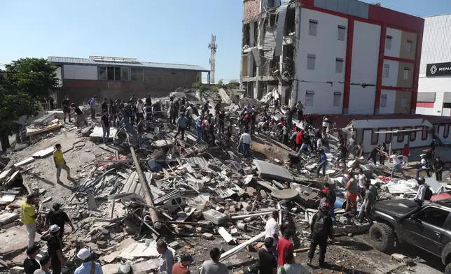 Residents and rescue workers search through the rubble of a collapsed building after an earthquake struck Cali, Colombia, Monday, Aug. 10, 2026. (AP Photo/Santiago Saldarriaga)