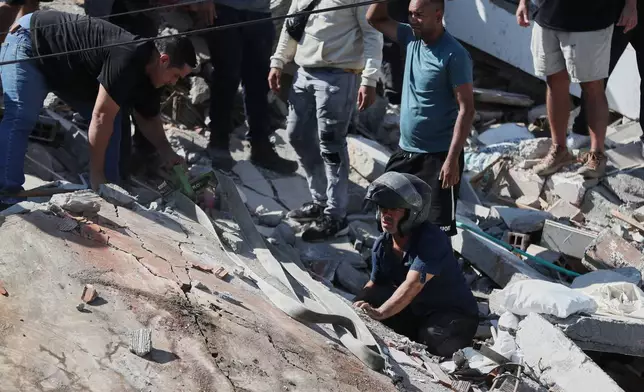 Residents and rescue workers search through the rubble of a collapsed building after an earthquake struck Cali, Colombia, Monday, Aug. 10, 2026. (AP Photo/Santiago Saldarriaga)