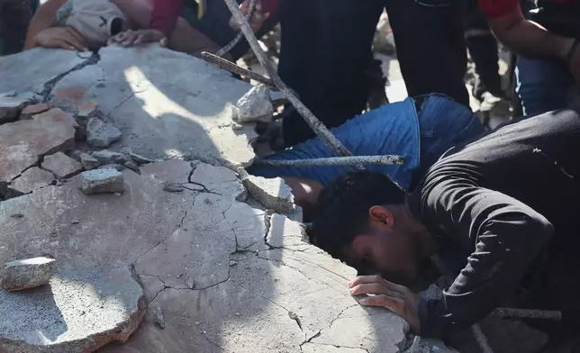 Residents and rescue workers search through the rubble of a collapsed building after an earthquake struck Cali, Colombia, Monday, Aug. 10, 2026. (AP Photo/Santiago Saldarriaga)