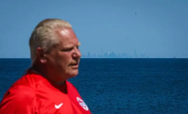 The Toronto skyline is seen across Lake Ontario as Ontario Premier Doug Ford speaks during an interview prior to the unveiling of a sign for Lake Ontario at Fifty Point Conservation Area in Grimsby, Ontario, Canada, on Saturday, Aug. 29, 2026. (Keito Newman/The Canadian Press via AP)