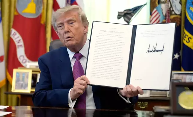 President Donald Trump holds up a signed executive order in the Oval Office of the White House, Thursday, Aug. 27, 2026, in Washington. (AP Photo/Manuel Balce Ceneta)