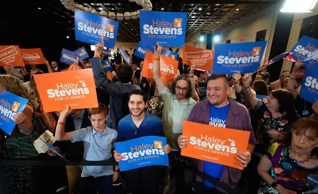 Attendees hold signs for Rep. Haley Stevens, D-Mich., a candidate in the Democratic primary for U.S. Senate in Michigan, during a primary election night event Wednesday, Aug. 5, 2026, in Detroit. (AP Photo/Paul Sancya)