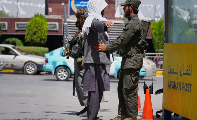 A Taliban security officer searches a man at a checkpoint ahead of celebrations marking the fifth anniversary of the U.S. withdrawal from Afghanistan and the start of Taliban rule, in Kabul, Afghanistan, Thursday, Aug. 13, 2026. (AP Photo/Siddiqullah Alizai)