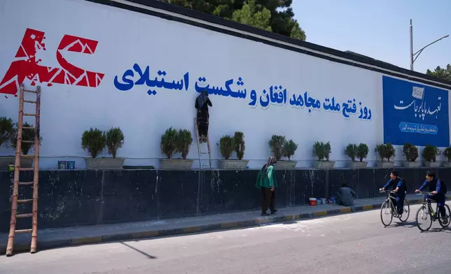 Workers paint a mural celebrating the Taliban's victory and the defeat of the U.S.-led occupation ahead of celebrations marking five years of Taliban rule, in Kabul, Afghanistan, Thursday, Aug. 13, 2026. (AP Photo/Siddiqullah Alizai)