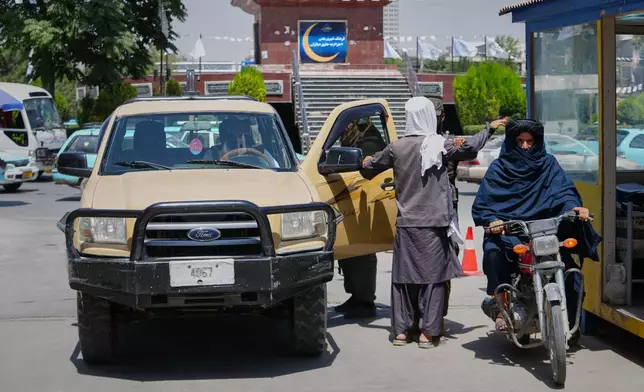 A Taliban security officer searches a man at a checkpoint ahead of celebrations marking the fifth anniversary of the U.S. withdrawal from Afghanistan and the start of Taliban rule, in Kabul, Afghanistan, Thursday, Aug. 13, 2026. (AP Photo/Siddiqullah Alizai)