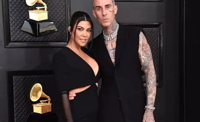 FILE - Kourtney Kardashian, left, and Travis Barker appear at the 64th Annual Grammy Awards in Las Vegas on April 3, 2022. (Photo by Jordan Strauss/Invision/AP, File)