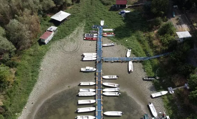 Boats sit on dry ground as water levels have dropped on the Danube River in Petrovaradin, Serbia, Tuesday, Aug. 25, 2026. (AP Photo/Darko Vojinovic)