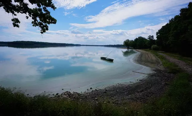 A fishing boat rests on a shore of Rozmberk pond near the town of Trebon, Czech Republic, Wednesday, Aug. 26, 2026. (AP Photo/Petr David Josek)