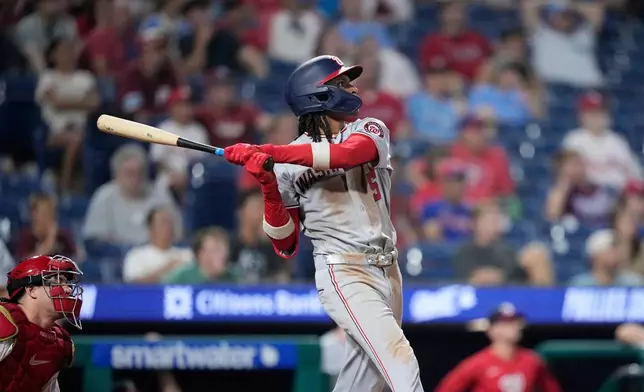 Washington Nationals' CJ Abrams follows through hitting a two-run triple against Philadelphia Phillies' Caleb Kilian during the 11th inning of a baseball game Wednesday, Aug. 5, 2026, in Philadelphia. (AP Photo/Matt Slocum)