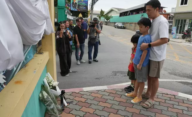 People offer prayers at the gate of Debsirin Nonthaburi School, a day after the shooting at the school in Nonthaburi province, Thailand, Saturday, Aug. 8, 2026. (AP Photo/Sakchai Lalit)