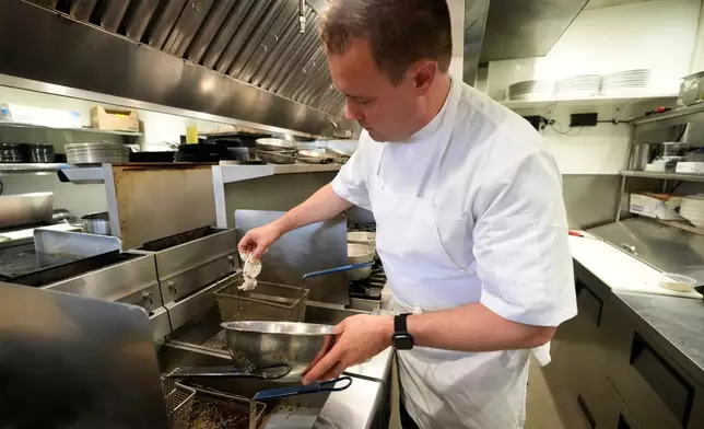 Executive chef Benjamin Hasty drops a breaded green crab into a fryer at Signal restaurant Tuesday, June 16, 2026, in Kennebunk, Maine. (AP Photo/Robert F. Bukaty)